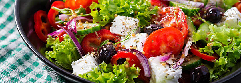mediterrane Ernährung, griechischer Salat mit Gurken, Tomaten, Paprika, Salat, roten Zwiebeln, Fetakäse, Oliven